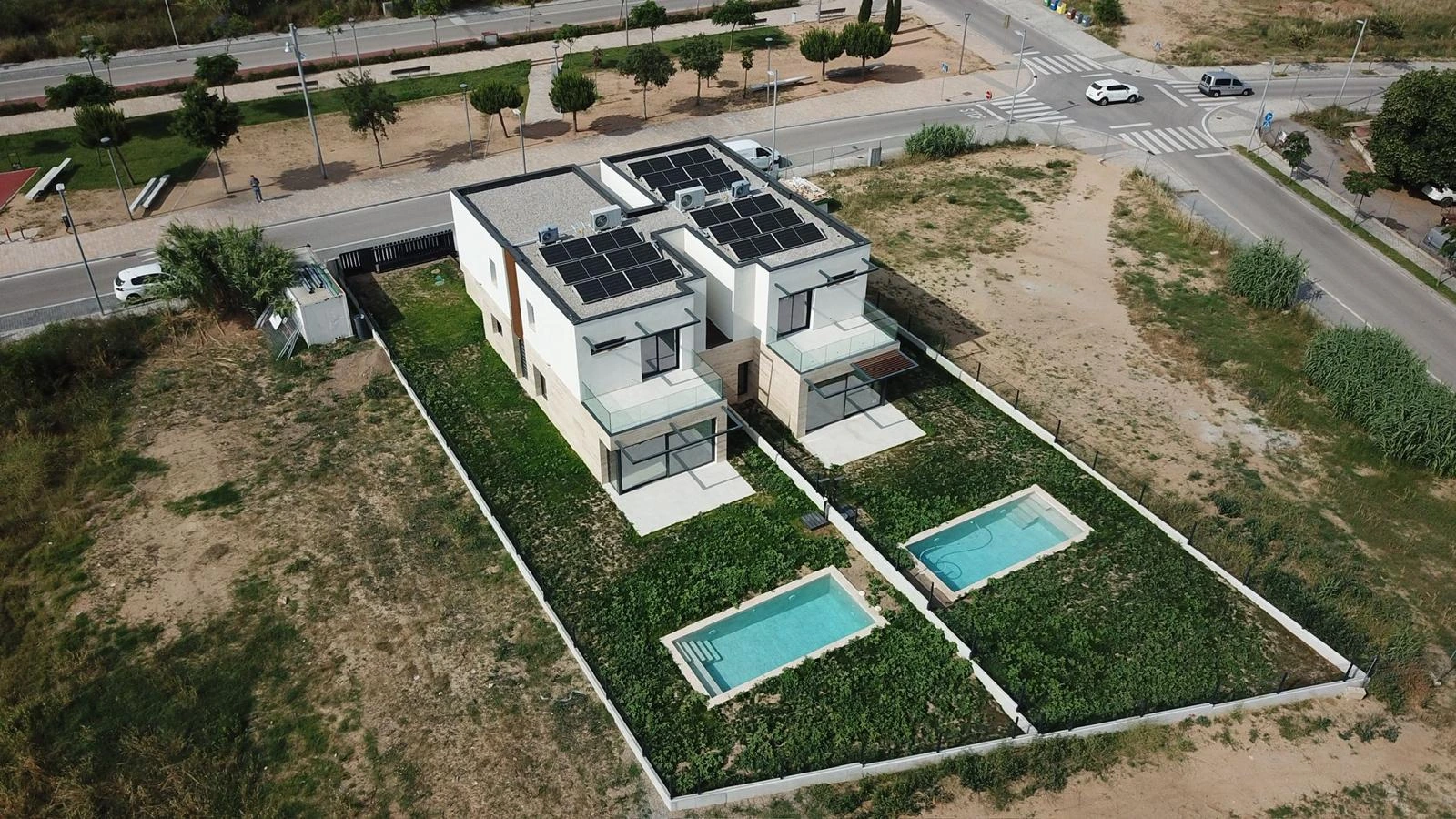 Vista aèria de dos habitatges unifamiliars amb jardí i piscina